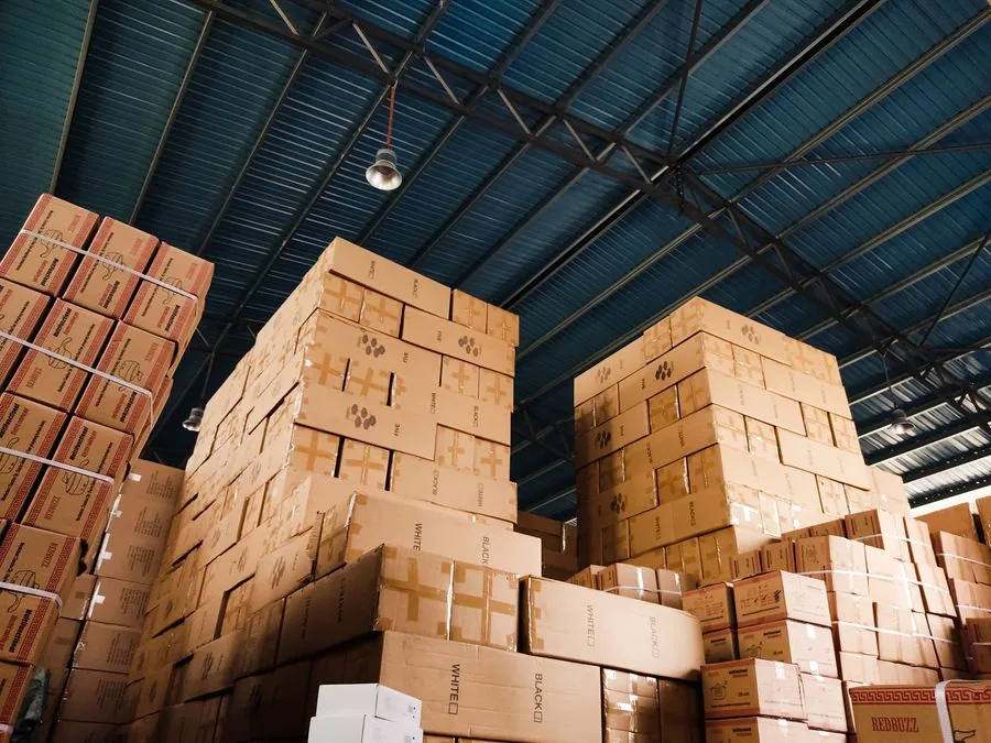 Pilas de cajas de cartón dentro de un almacén de techo alto